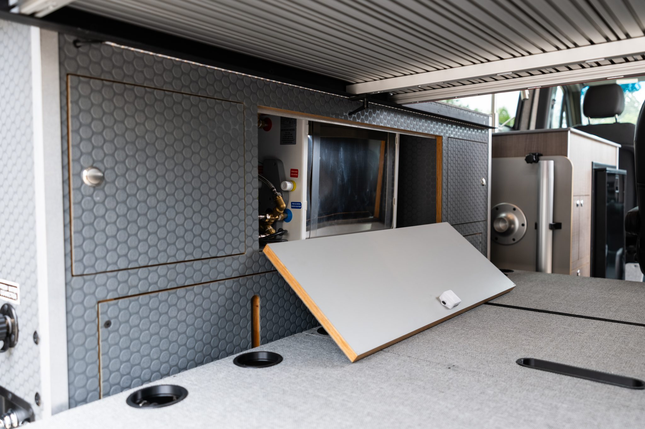 Camper van under-bed compartment with the water heater