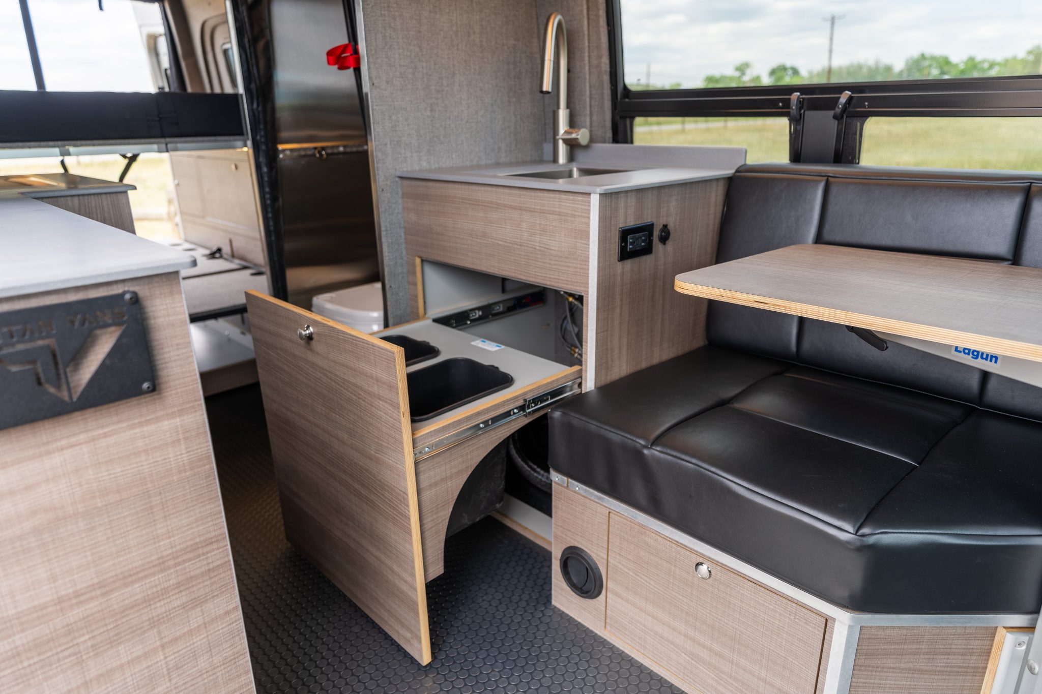 Camper van galley sink with the slide-out waste drawer open