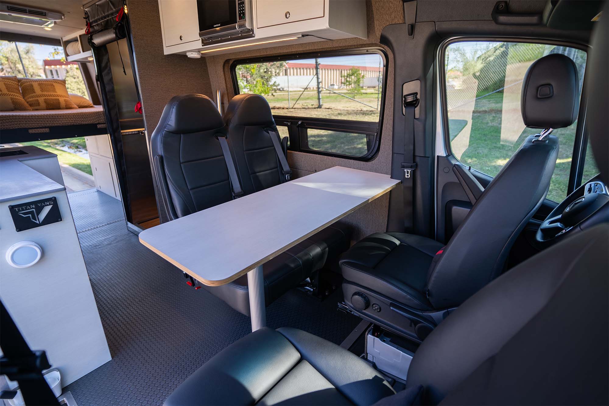 Camper van interior living area with marine table and seats facing it