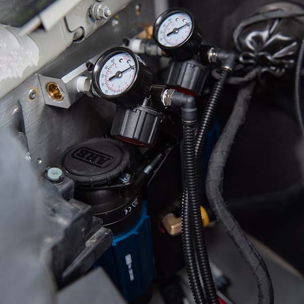 air compressor installed in engine bay of camper van