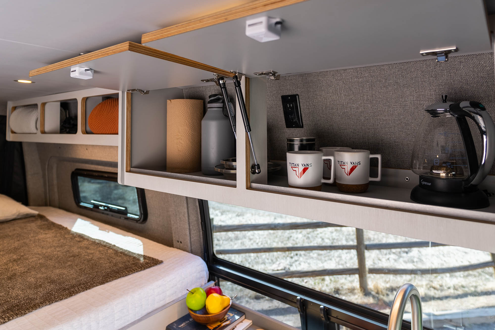 The overhead cabinets and cubby shelves of the Kronos camper van