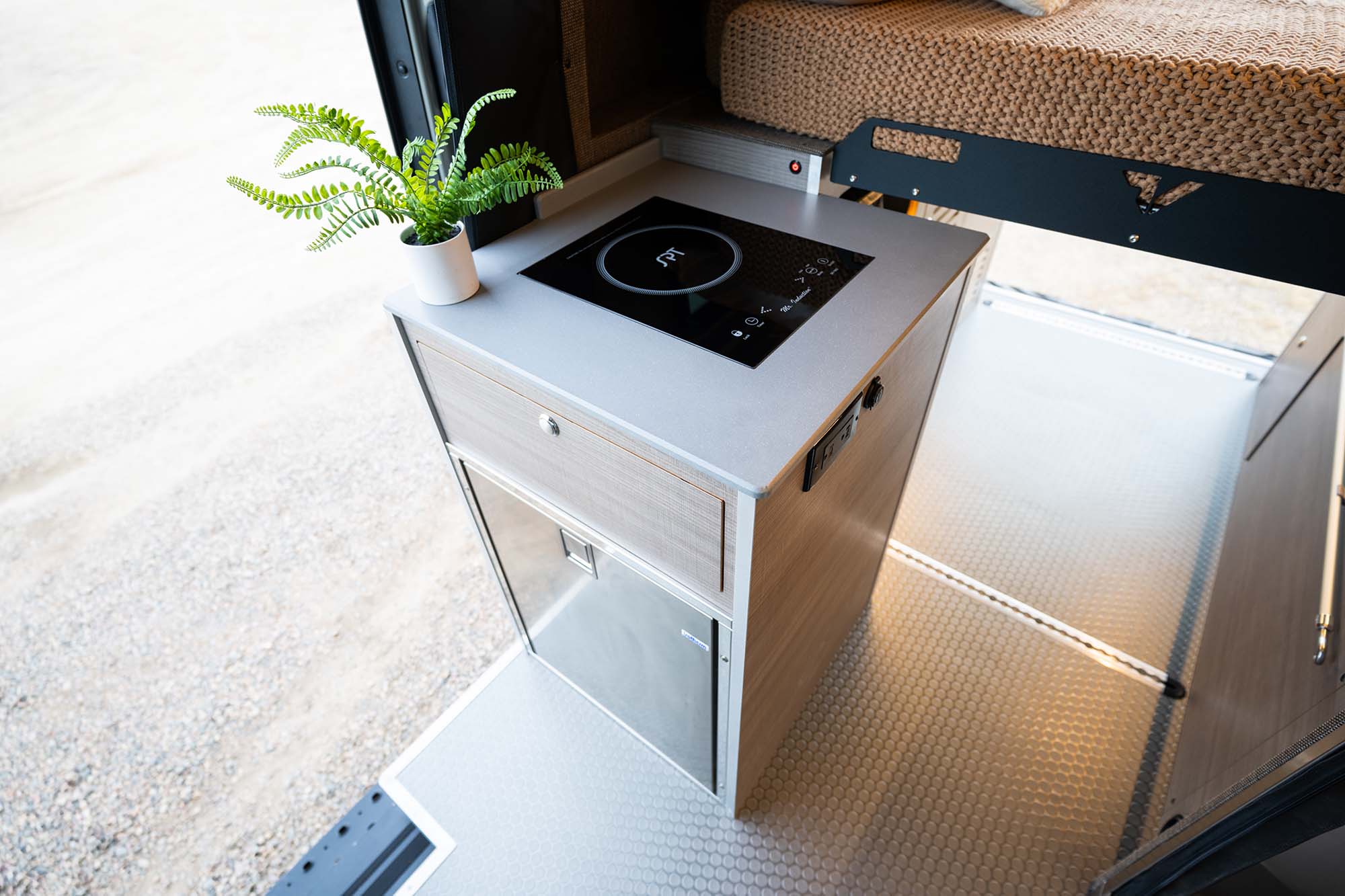 A stainless steel drawer fridge that is also accessible from outside the van